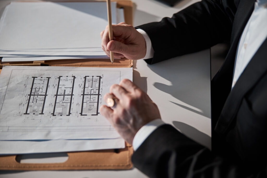 male architect working on building plan in office